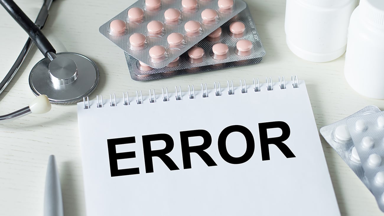 notebook with the word "error" surrounded by pills and stethescope