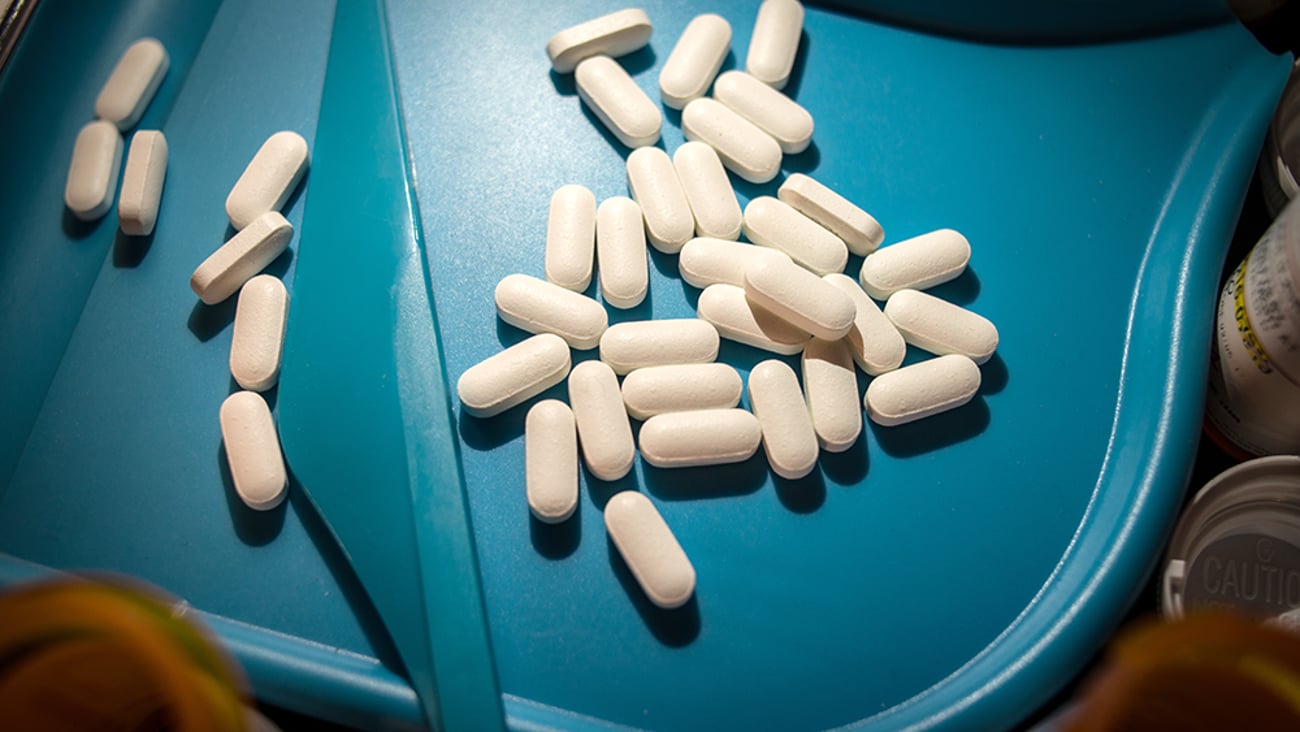 white pills on pharmacist's sorting tray