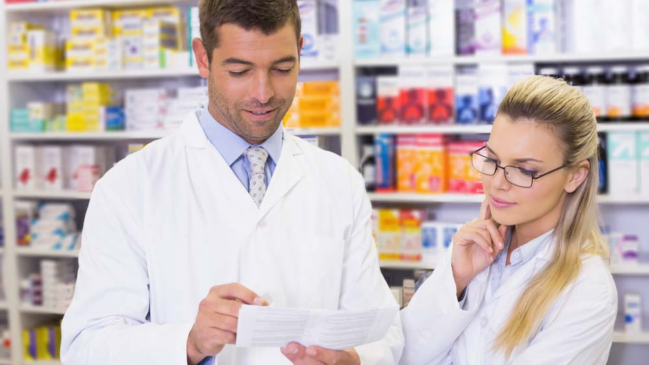 experienced pharmacist teaching younger pharmacist or technician