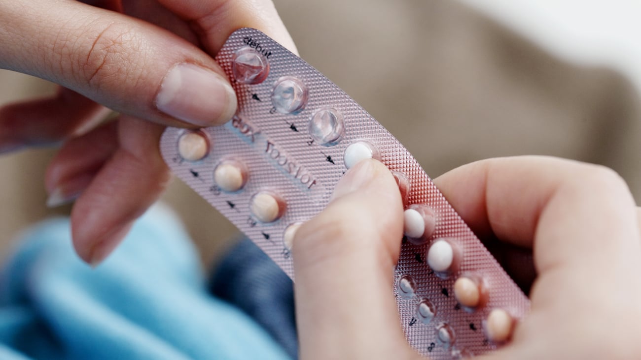 Woman holding packet of birth control pills