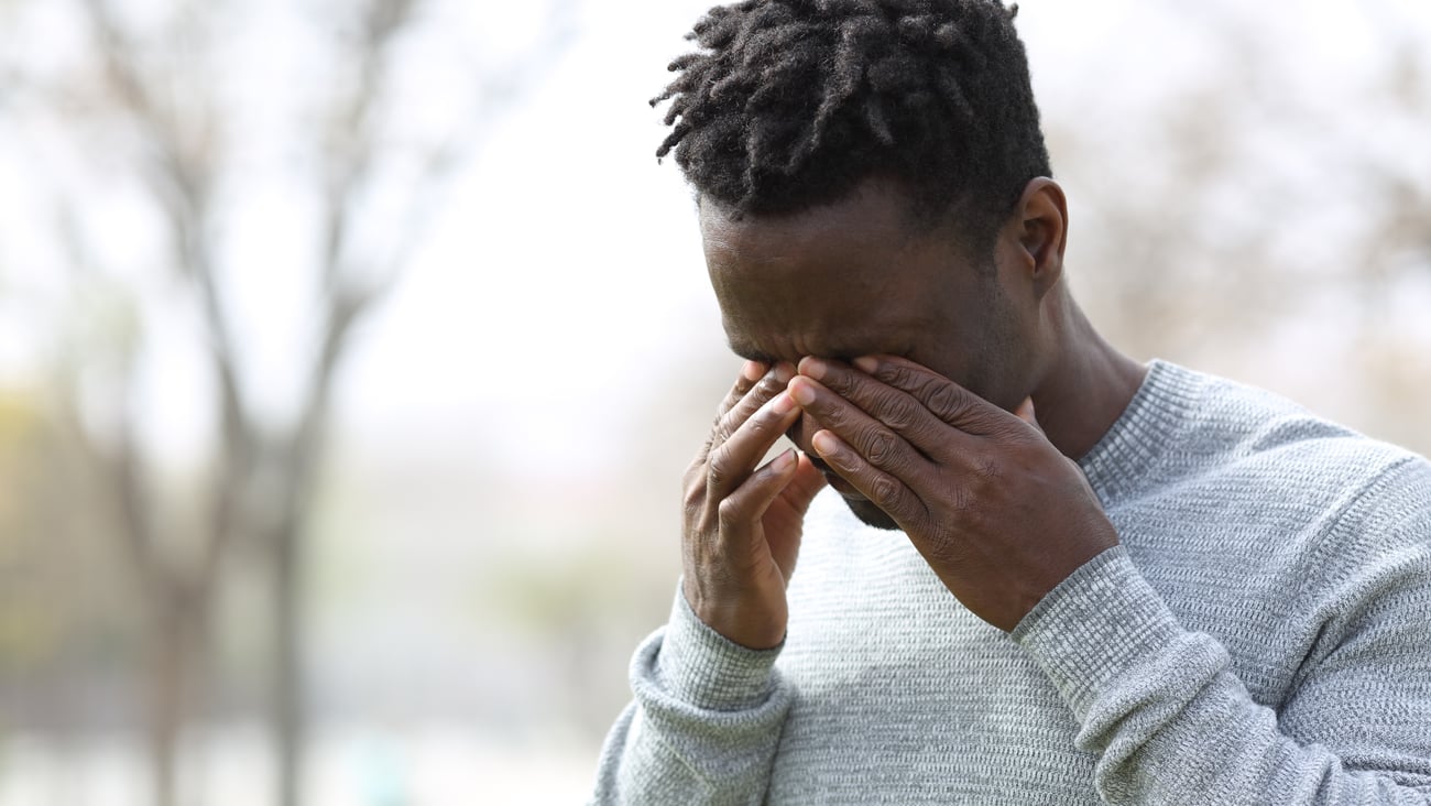 Young man rubbing his eyes