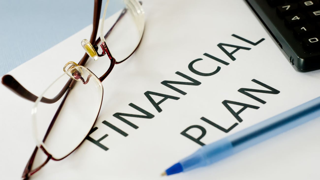 financial plan with reading glasses and calculator