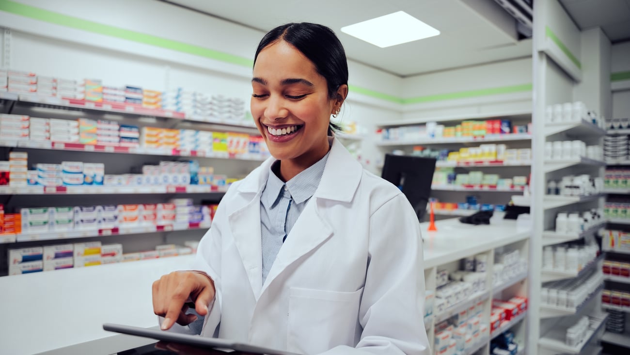 Pharmacist smiling while reading her tablet