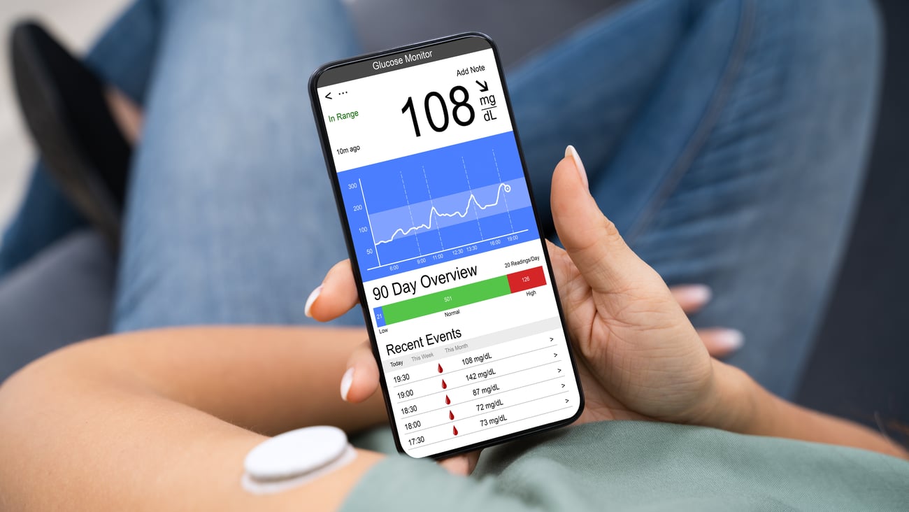 Young person reading data about their glucose levels on their smartphone