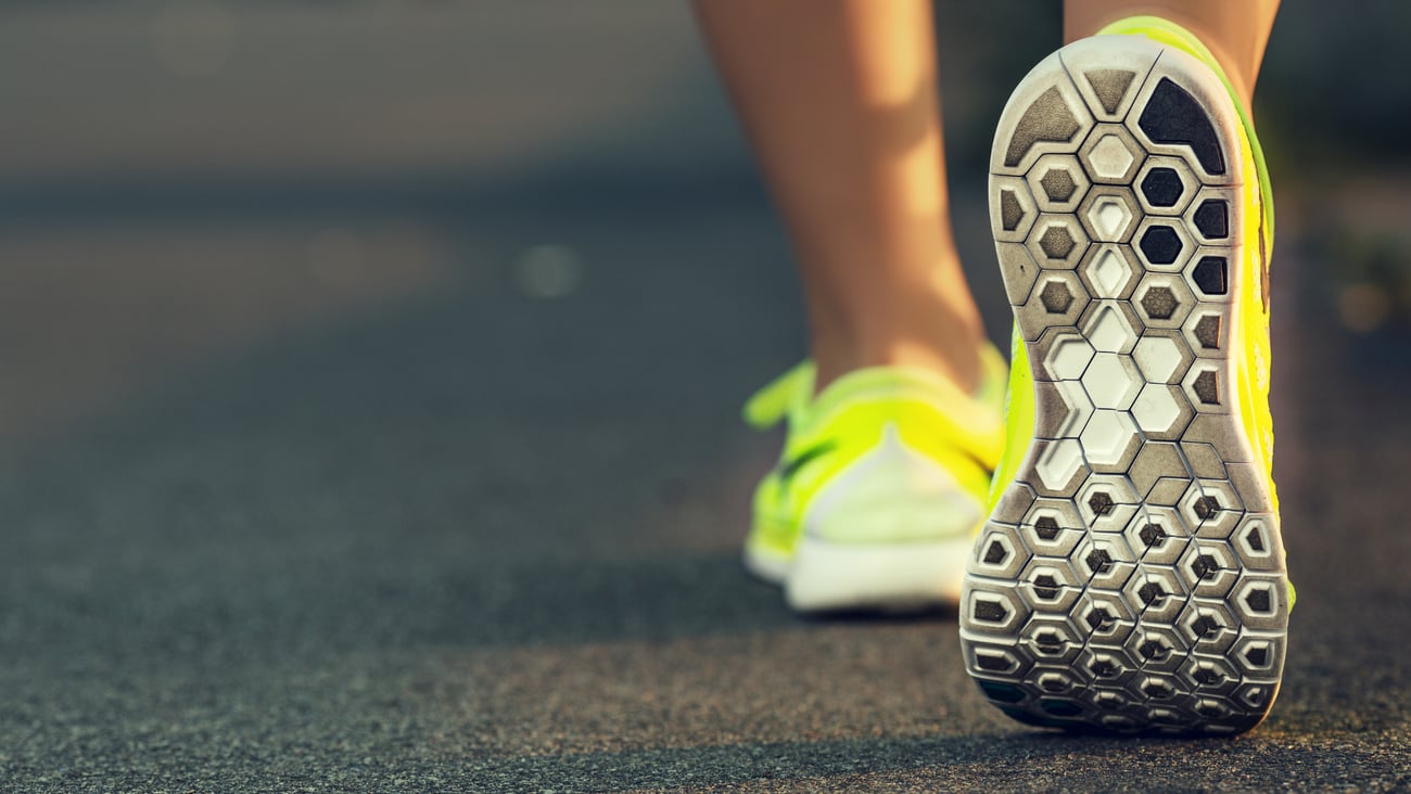 Close-up of a woman walking away in tennis shoes