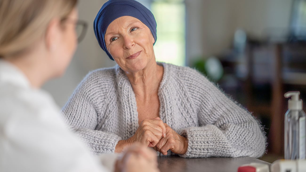 an older female cancer patient discusser her care with a pharmacist