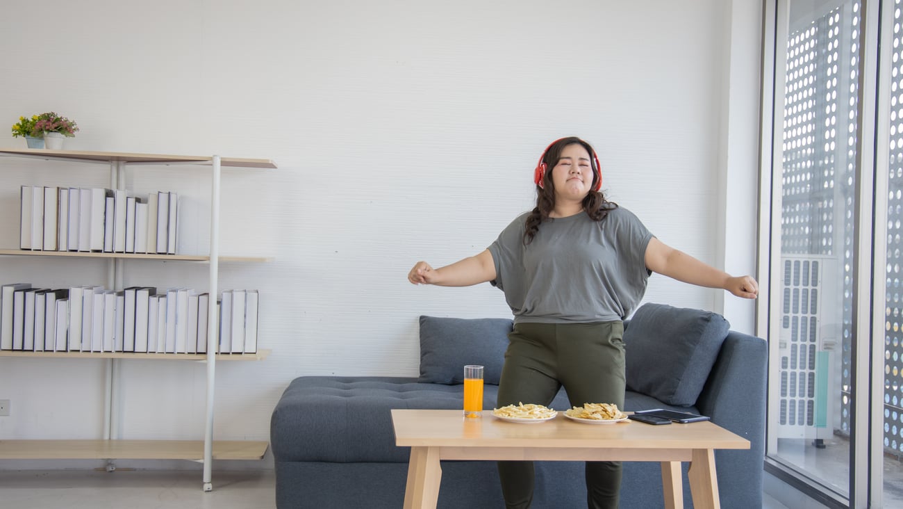 Young Asian woman dancing in her living roon