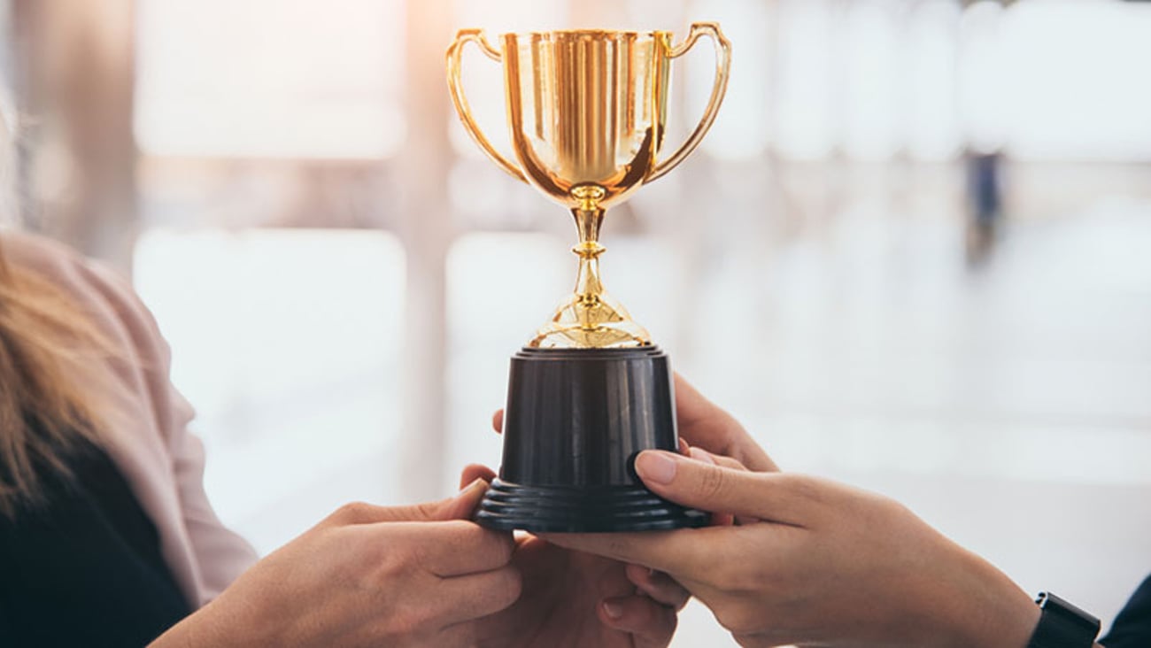 an award in the form of a gold trophy is presented to an anonymous person