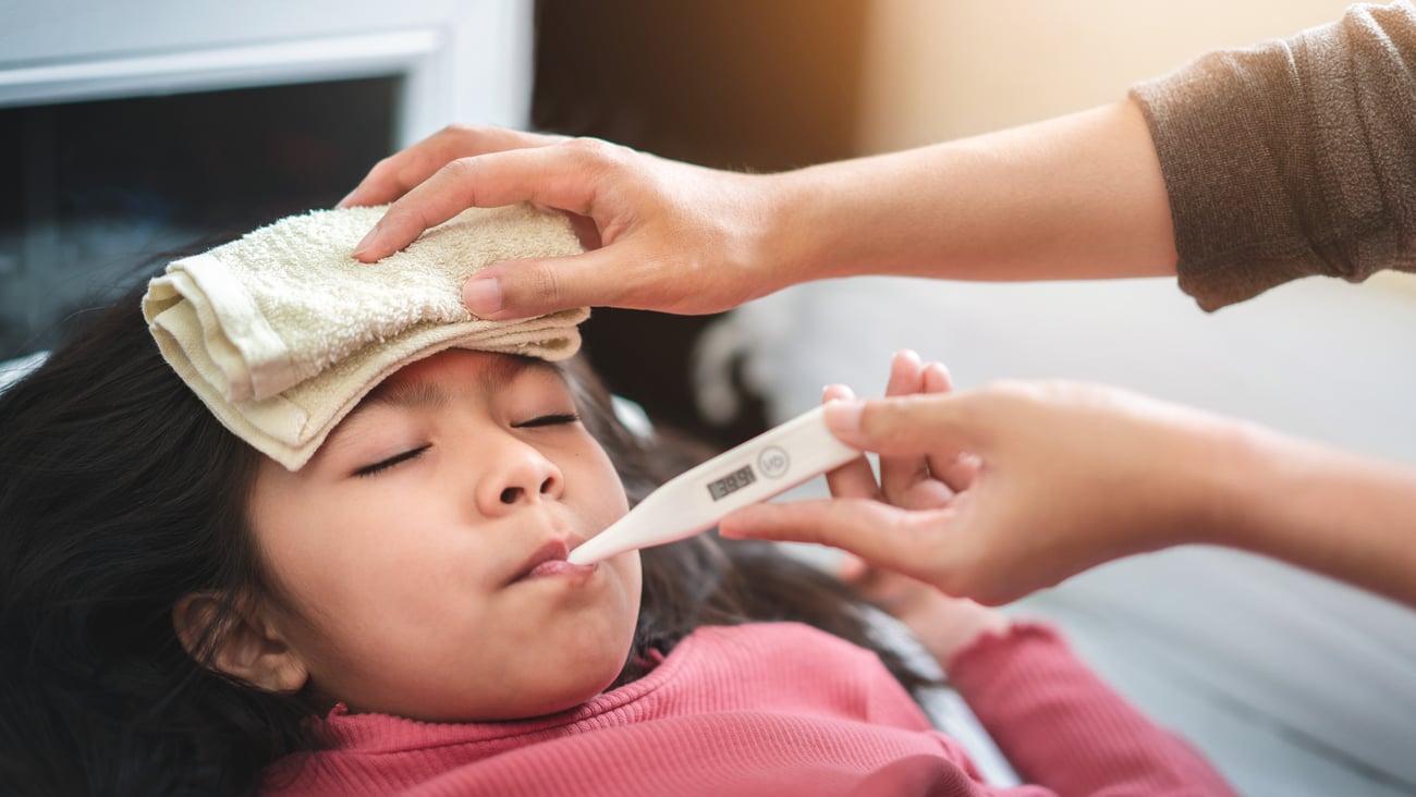 Young girl having her temperature taken