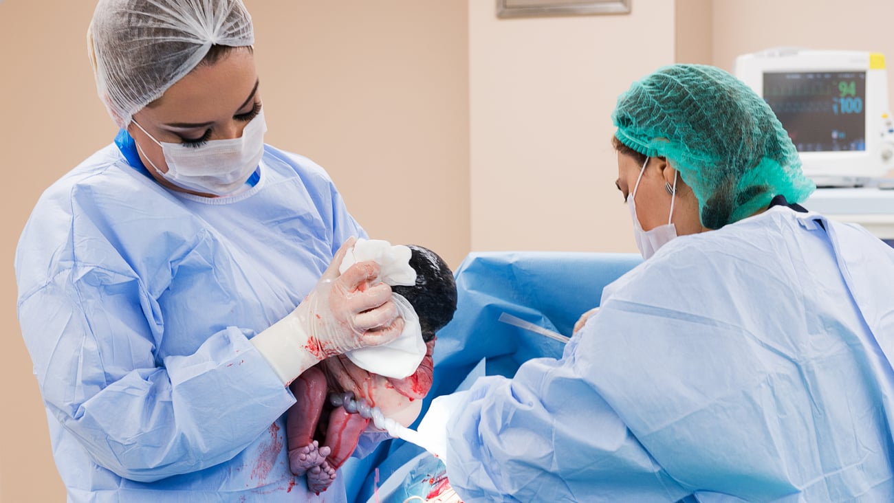 Two healthcare workers delivering a baby