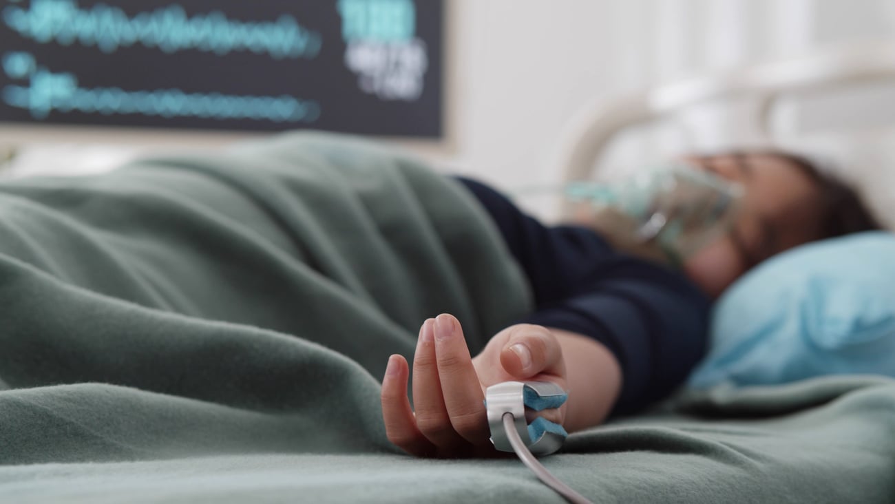 Young woman lying in bed in ICU 