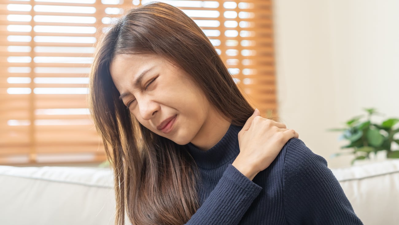 Woman holding her shoulder in pain