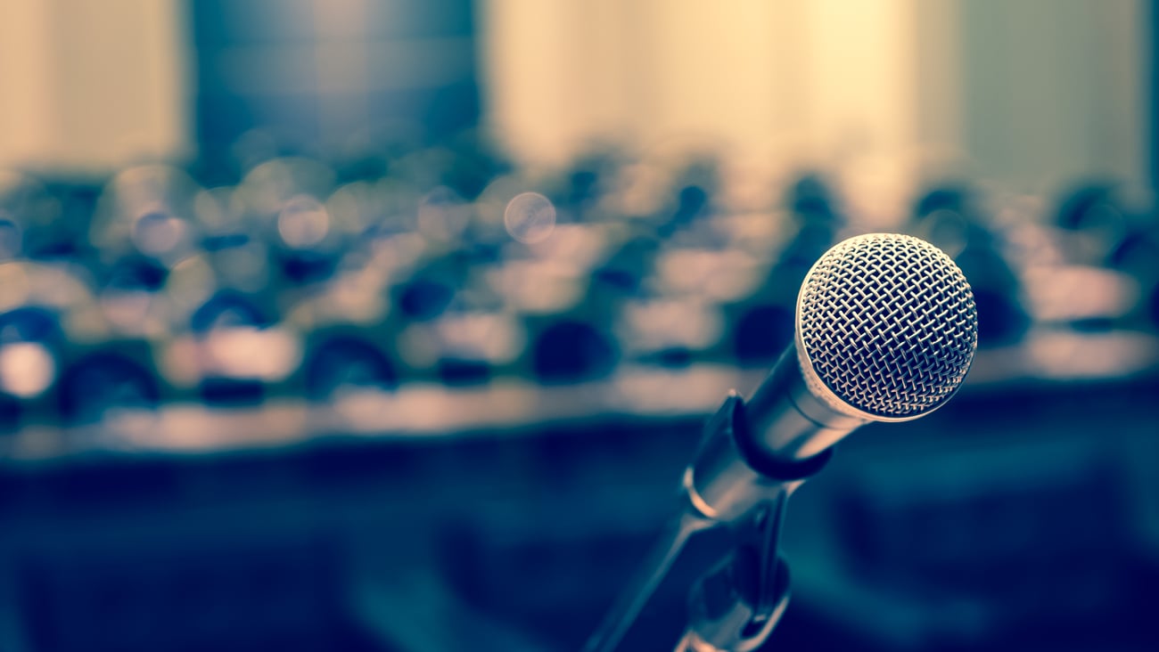 Microphone closeup in front of an empty room waiting for a presentation