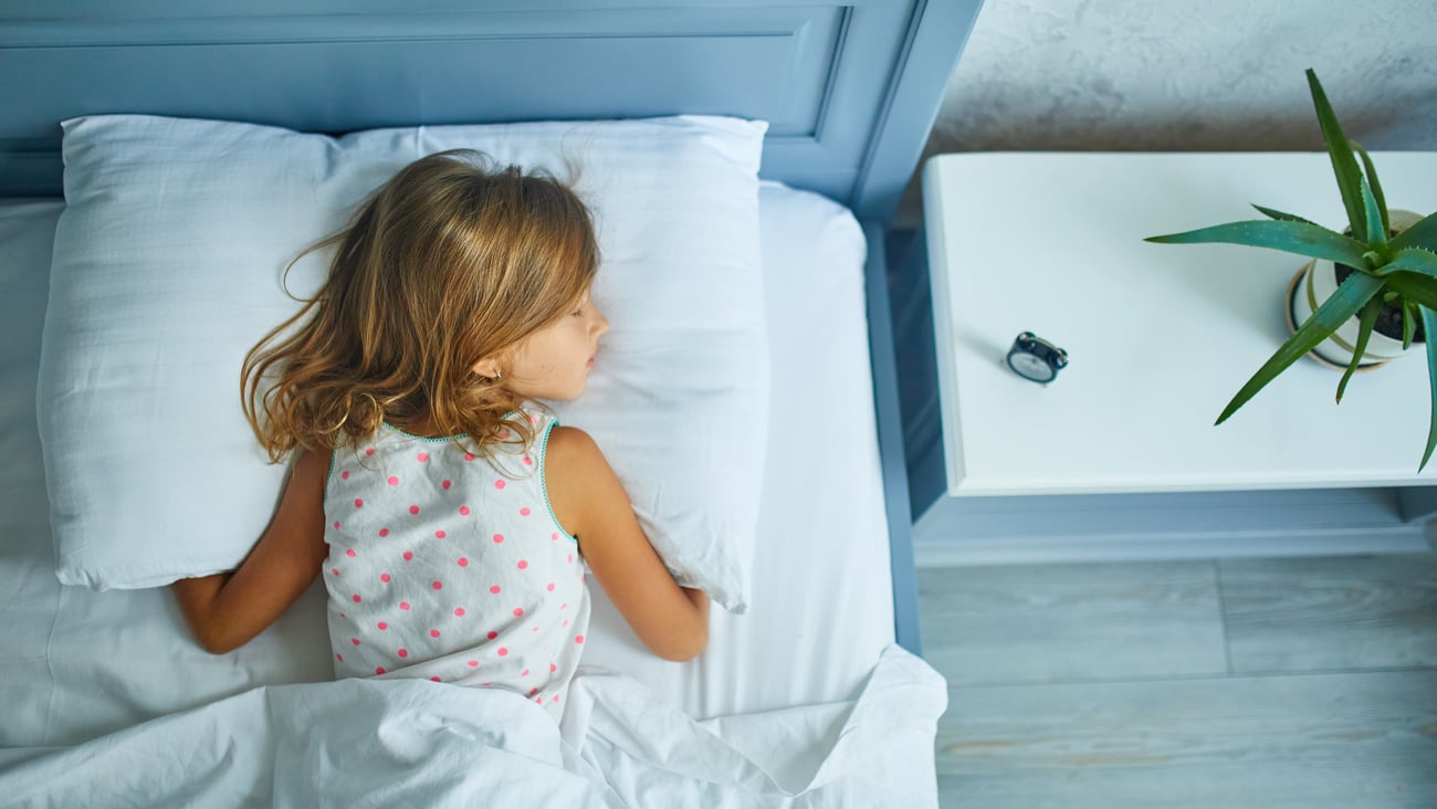 a little girl sitting on a bed