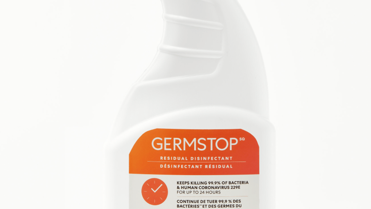 Picture of a white spray bottle with an orange label against a white background