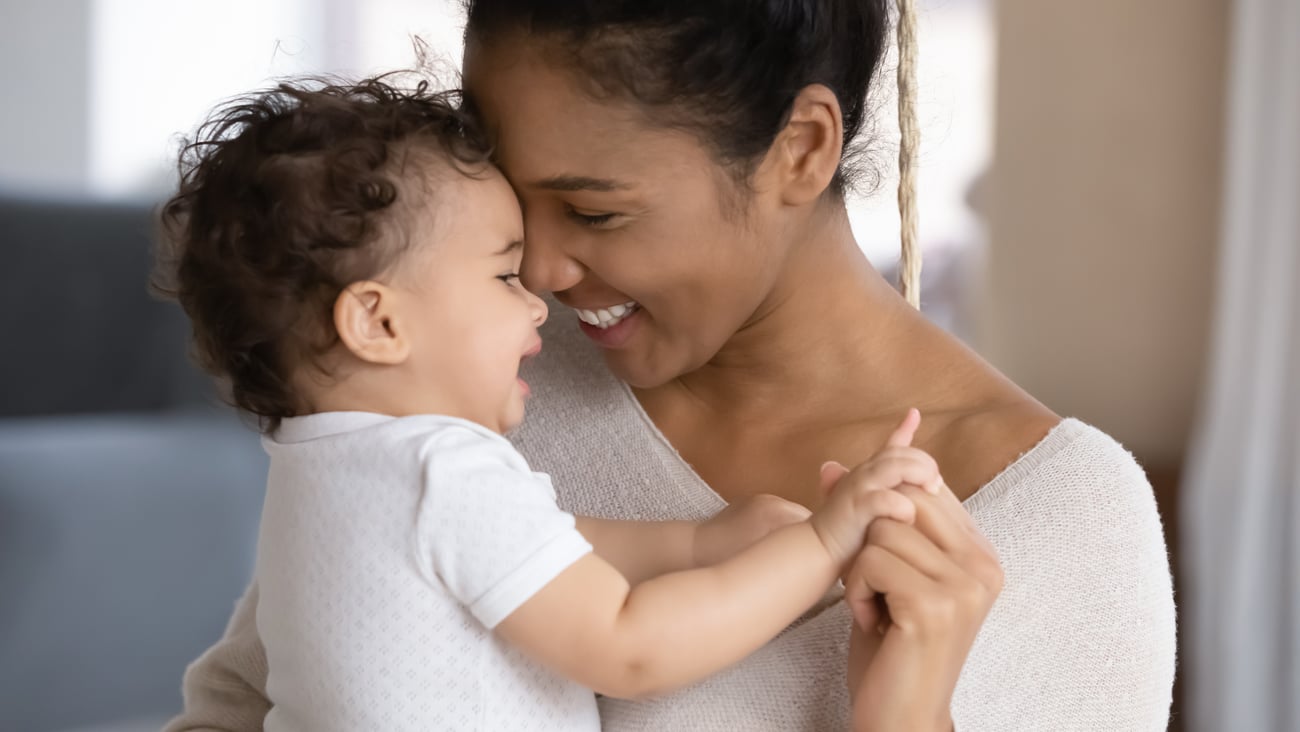 Young mother holding her baby close and smiling