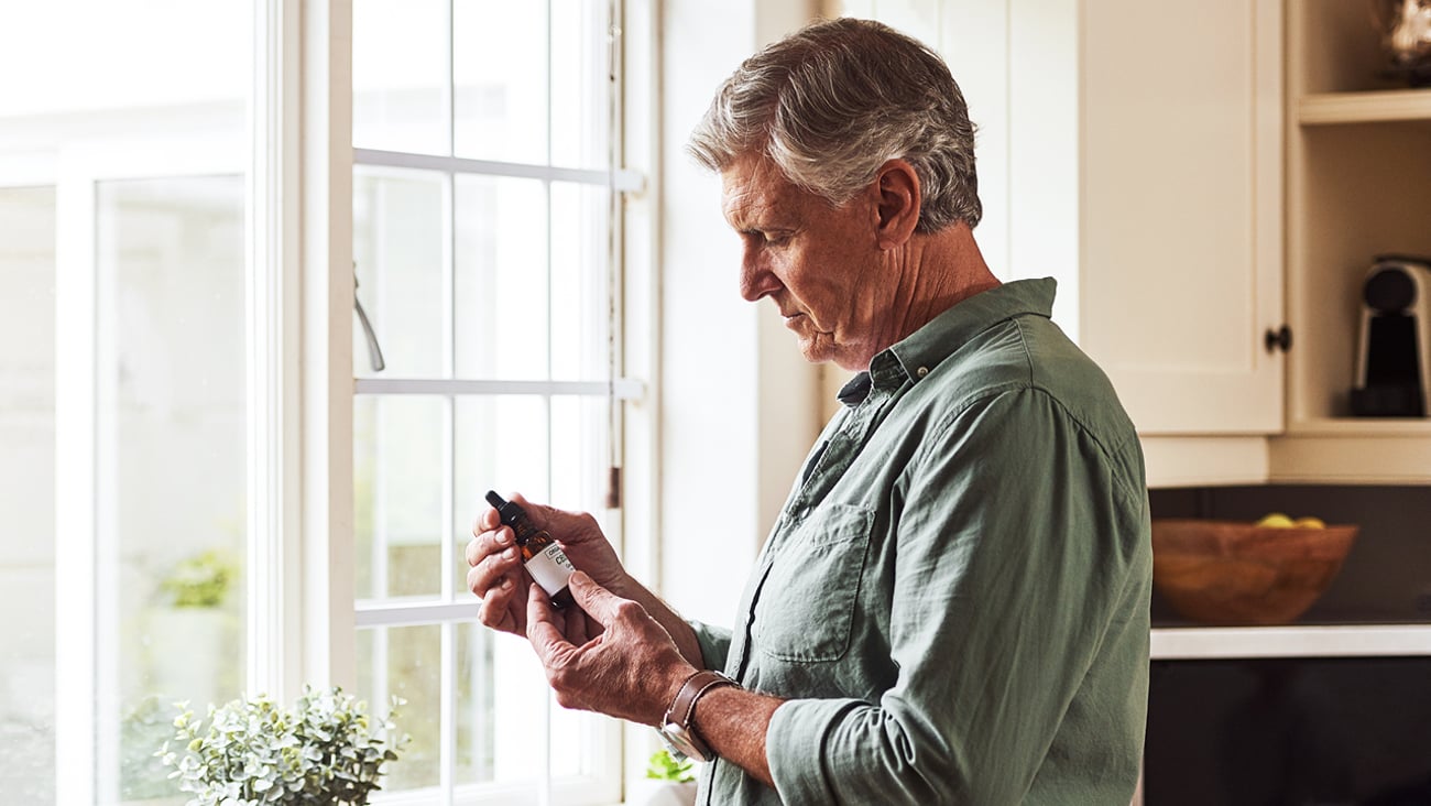 Older man looks at cannabis products