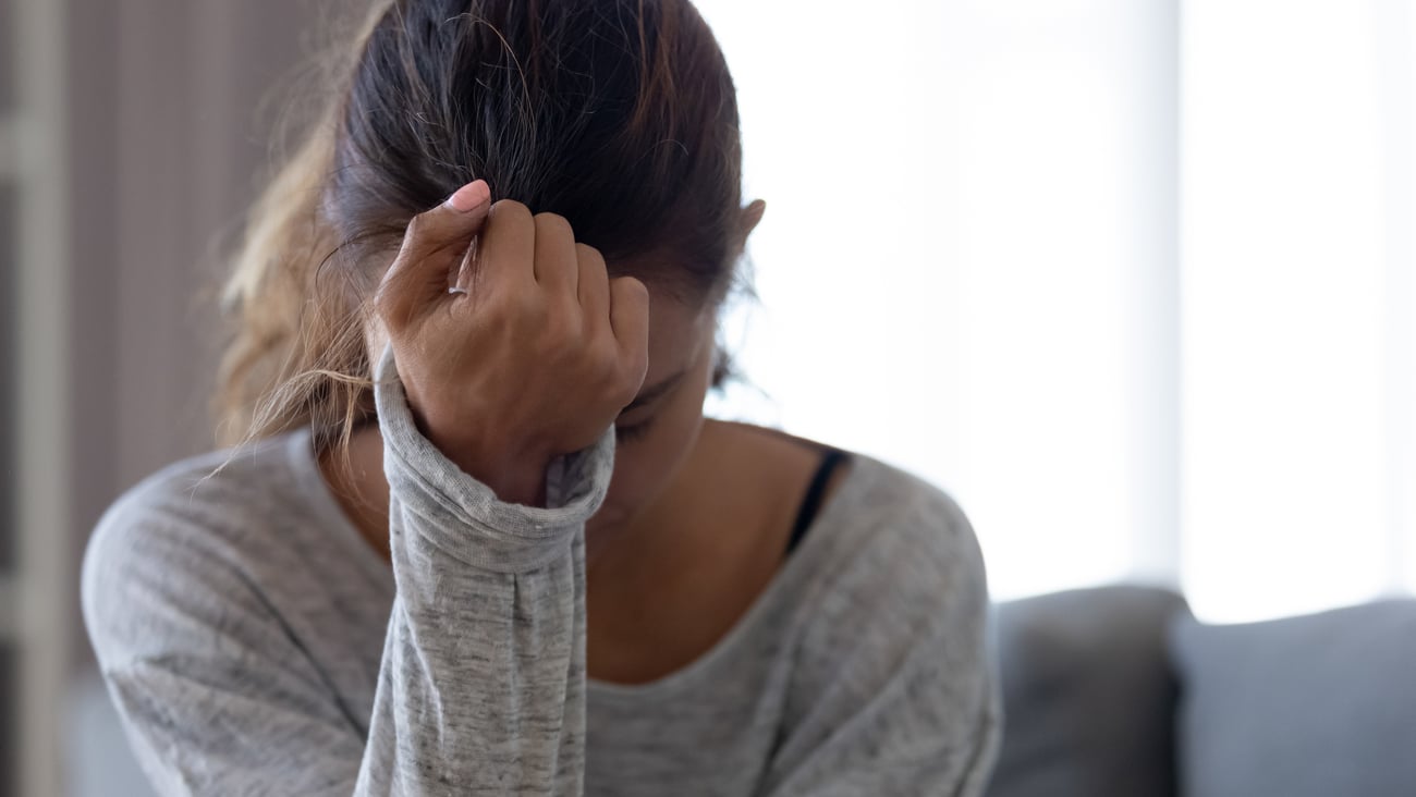 Teenage girl hiding her her face with a closed fist