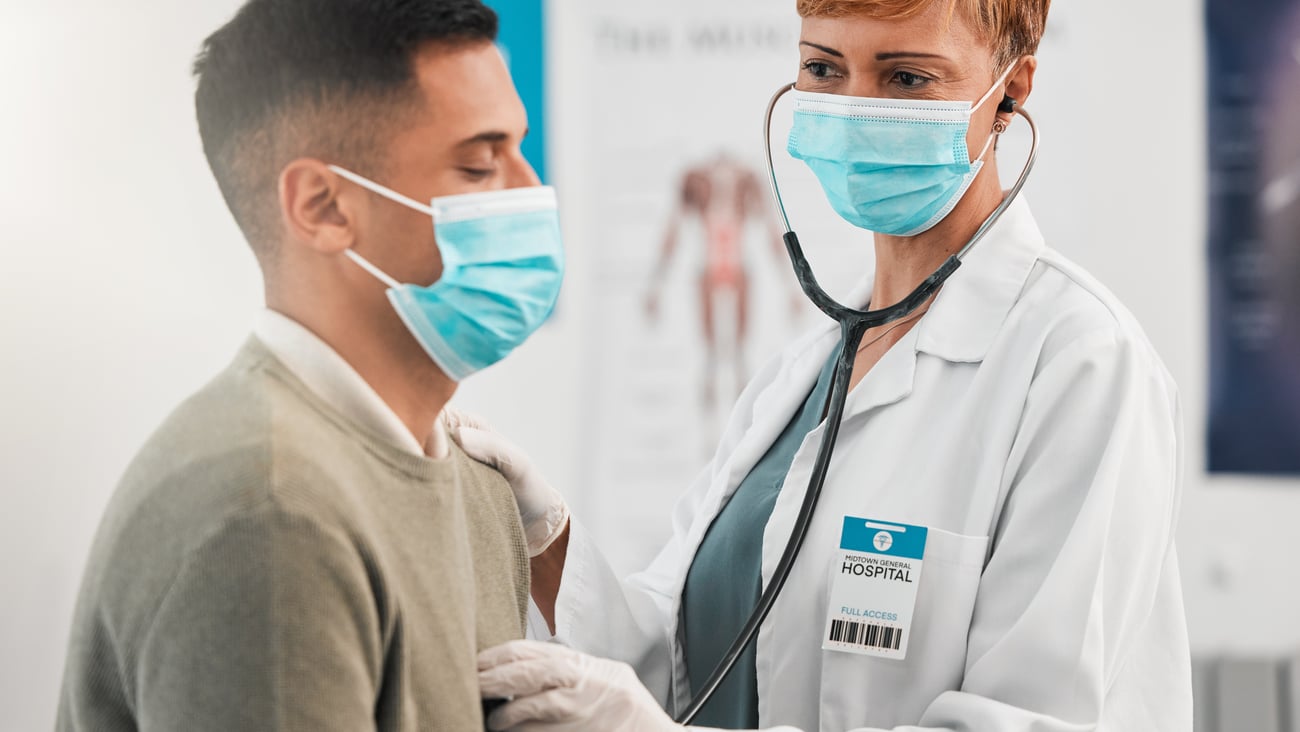 Mature woman physician listening the heartbeat of a young male patient