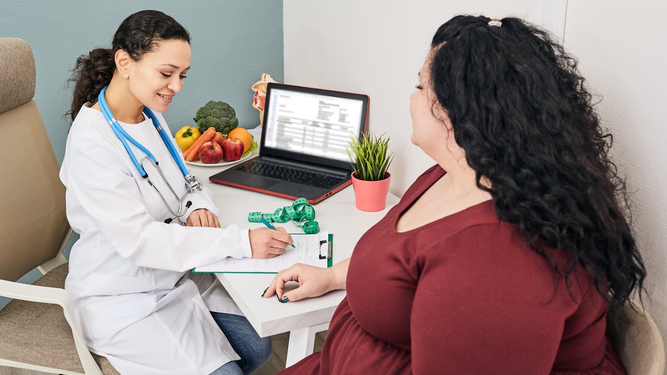 large woman consulting with smiling doctor