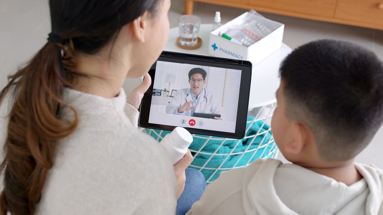 Young woman holding a tablet for a video call with a pharmacist