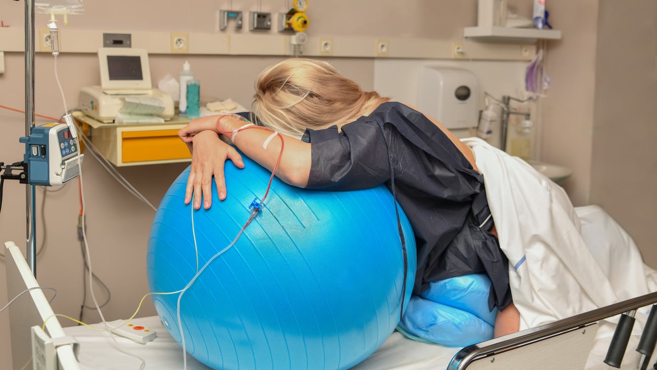 Pregnant woman in labour leaning over an exercise ball