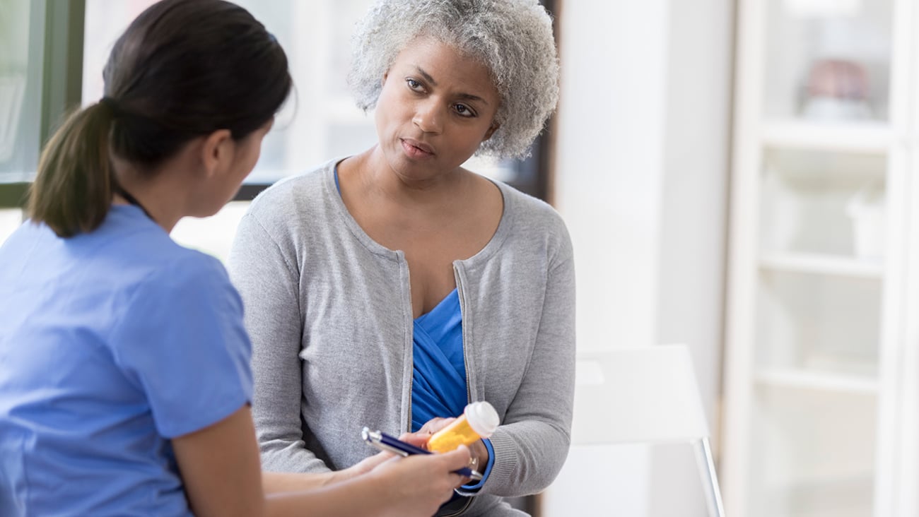 Pharmacist discussing medications with an older woman patient