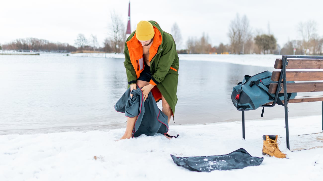Man coming out of icy lake after a cold plunge