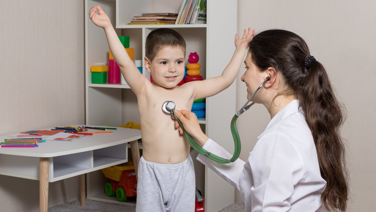 female white pediatrician with white little boy, stethoscope to chest