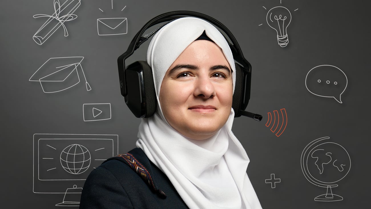 Pharmacist Shams Qaend wearing a white hijab and a black over-the-ear headset