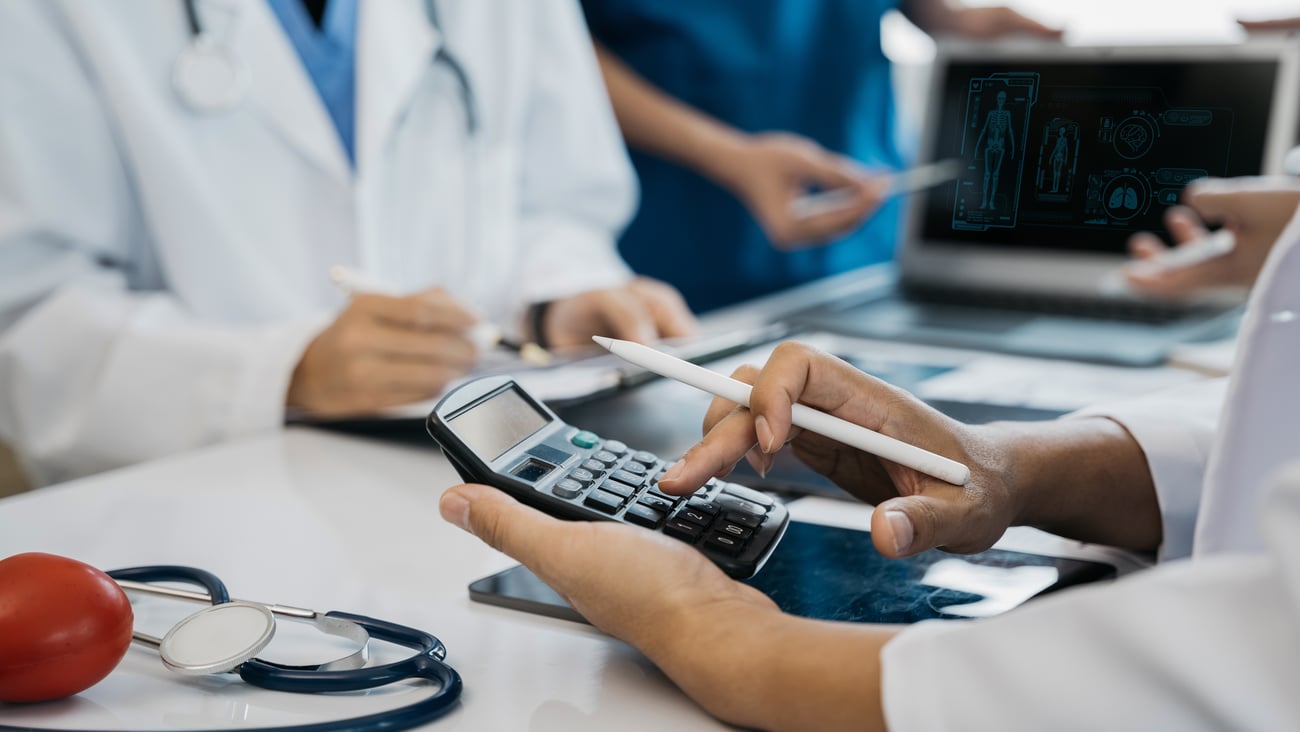 A doctor using a calculator to calculate fees