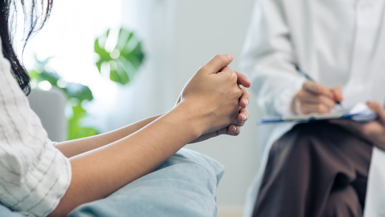 hands of patients across from doctor with clipboard, both female
