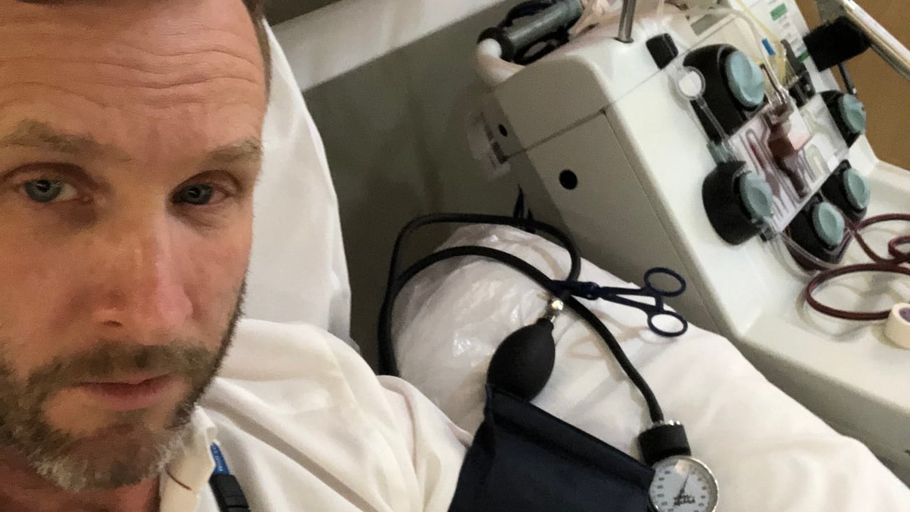Dr. Jacob Pendergrast, a fair-faced man looking sleepy with a blood-pressure cuff on his arm