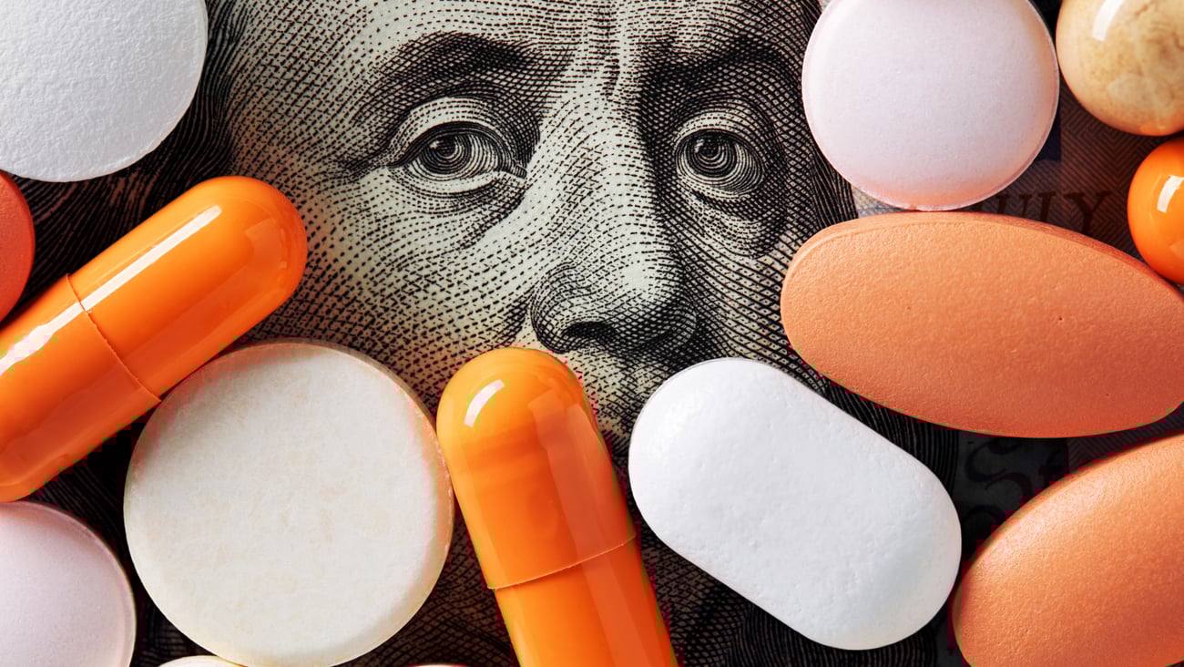 Pills on top of U.S. $100 bill suggesting cost of medication