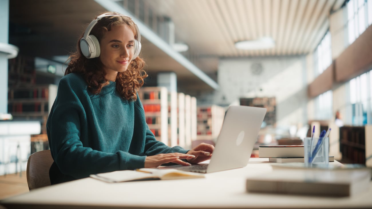 A woman at library taking an online course on her laptop