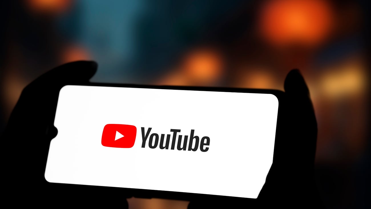 The YouTube logo is seen on a phone screen.