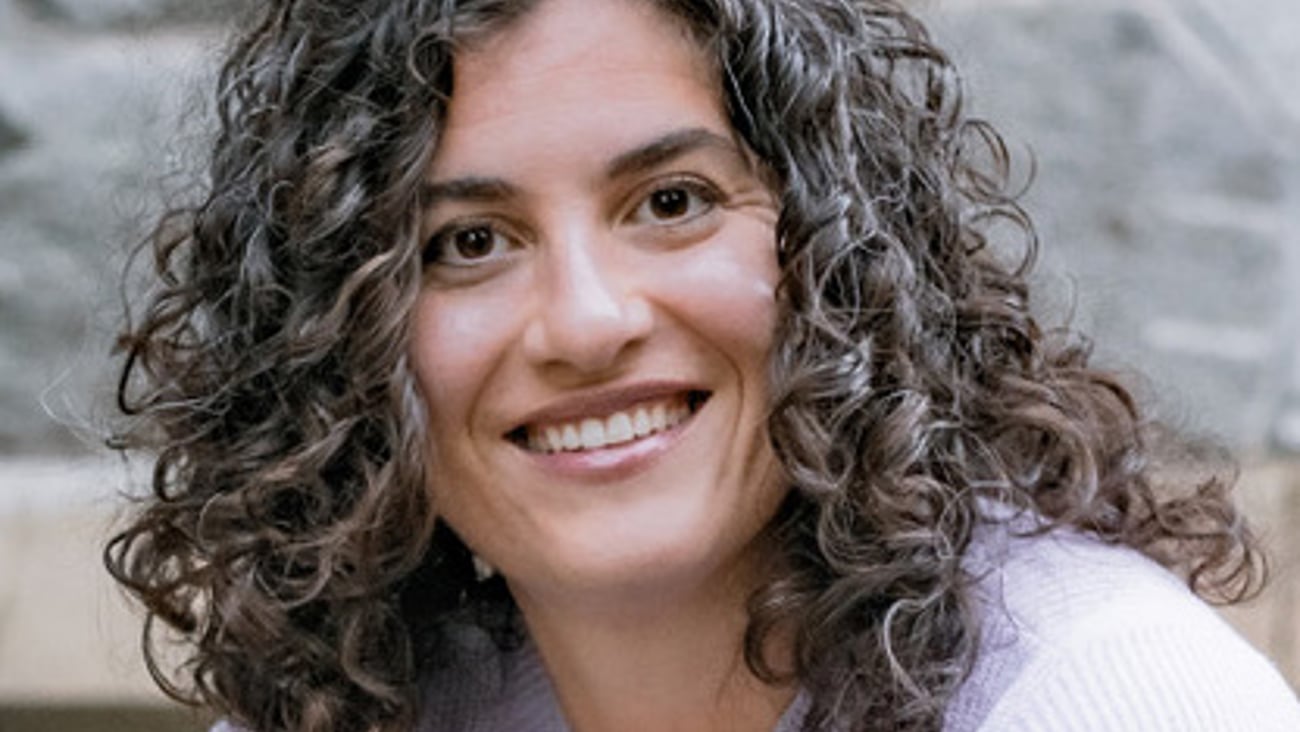 Female physician Dr. Ginevra Mills smiles at the camera