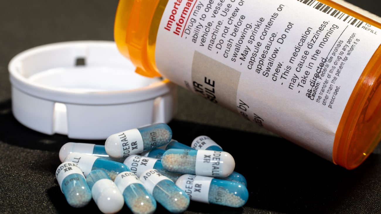 Pill bottle on its side, with some Adderall pills spilled out