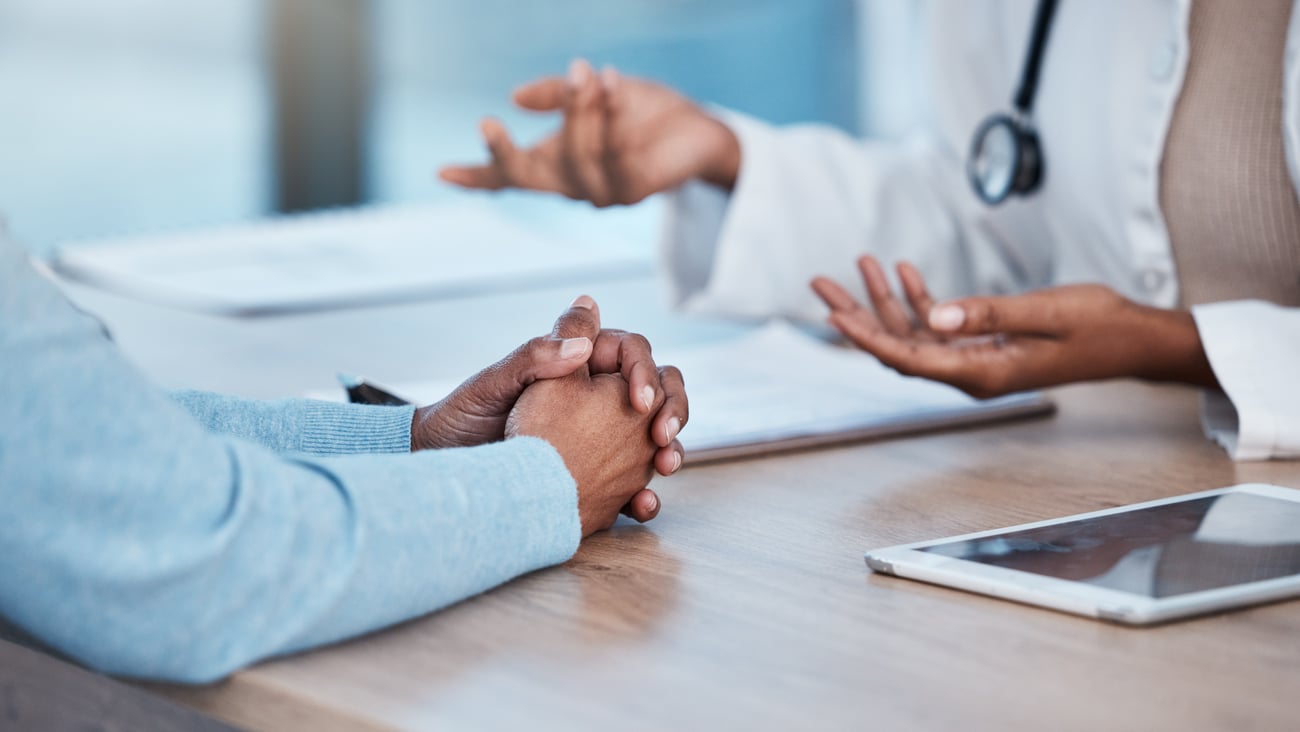 Close up of hands of a doctor and patient as they have a discussion
