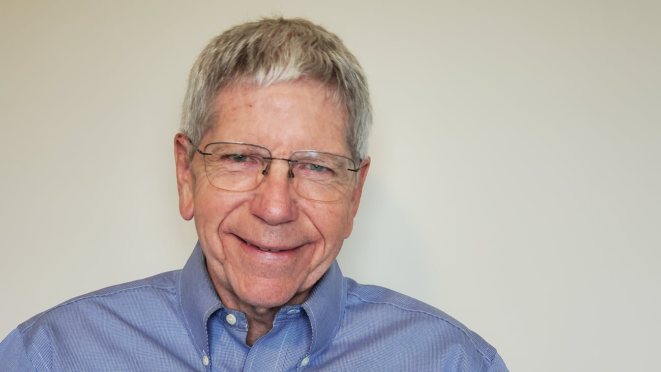 Older man with glasses in a blue shirt