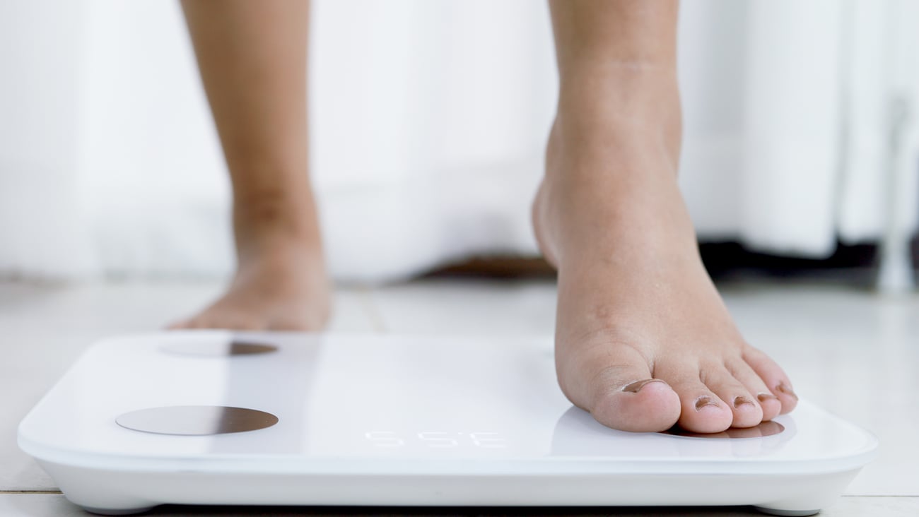 Woman stepping onto a scale