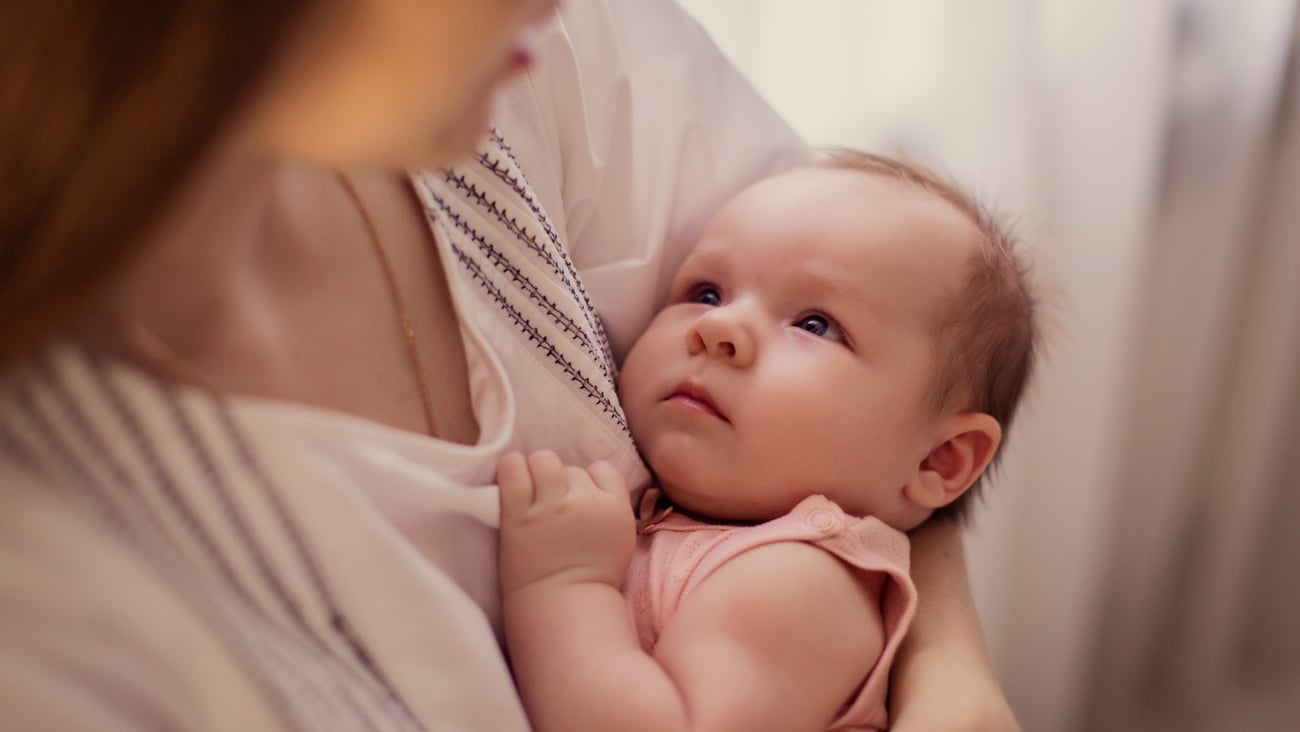 Baby being held in mother's arms