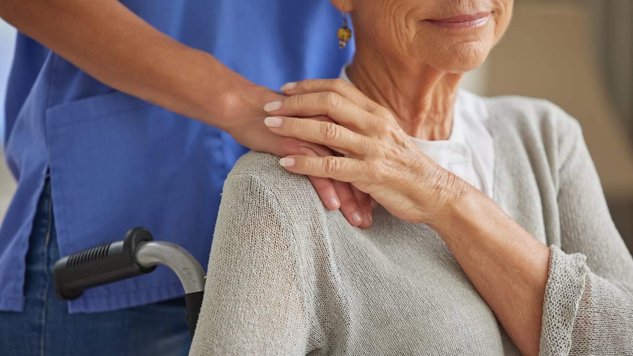 Hand, nurse and elderly woman patient with disability holding hands homecare worker for empathy, kindness and healthcare supporCaregiver, volunteer and trust help for senior woman in wheelchair