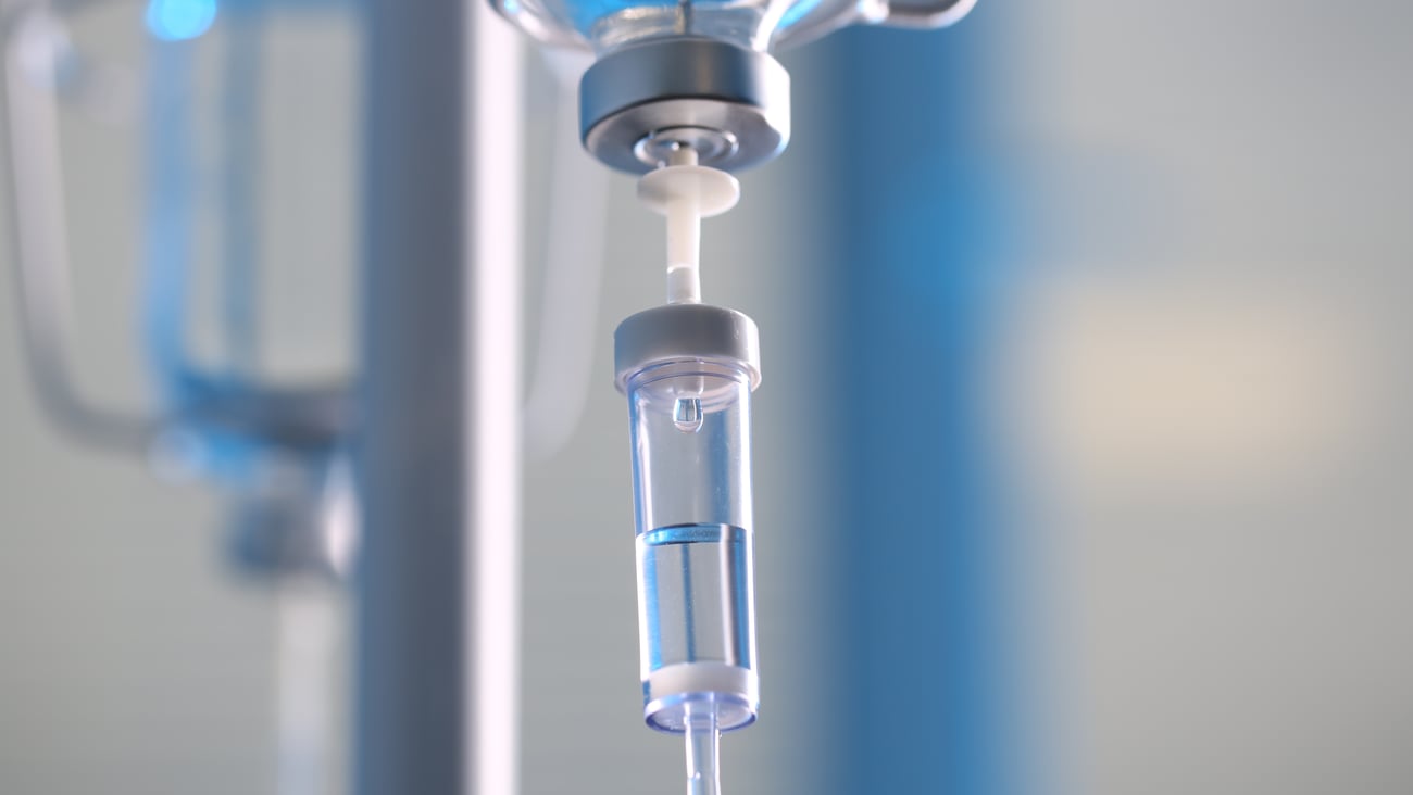 IV drip chamber against blurred light background