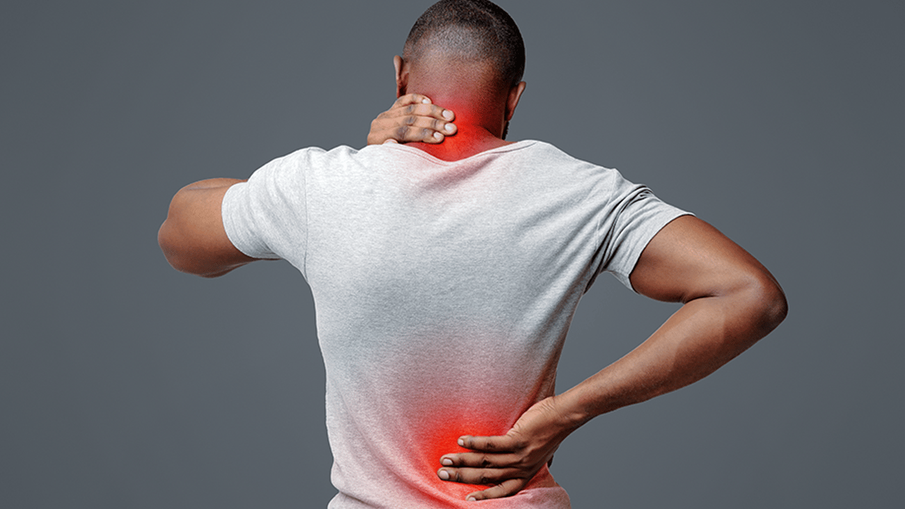 Man with neck and back pain, rubbing his painful body over white background, back view