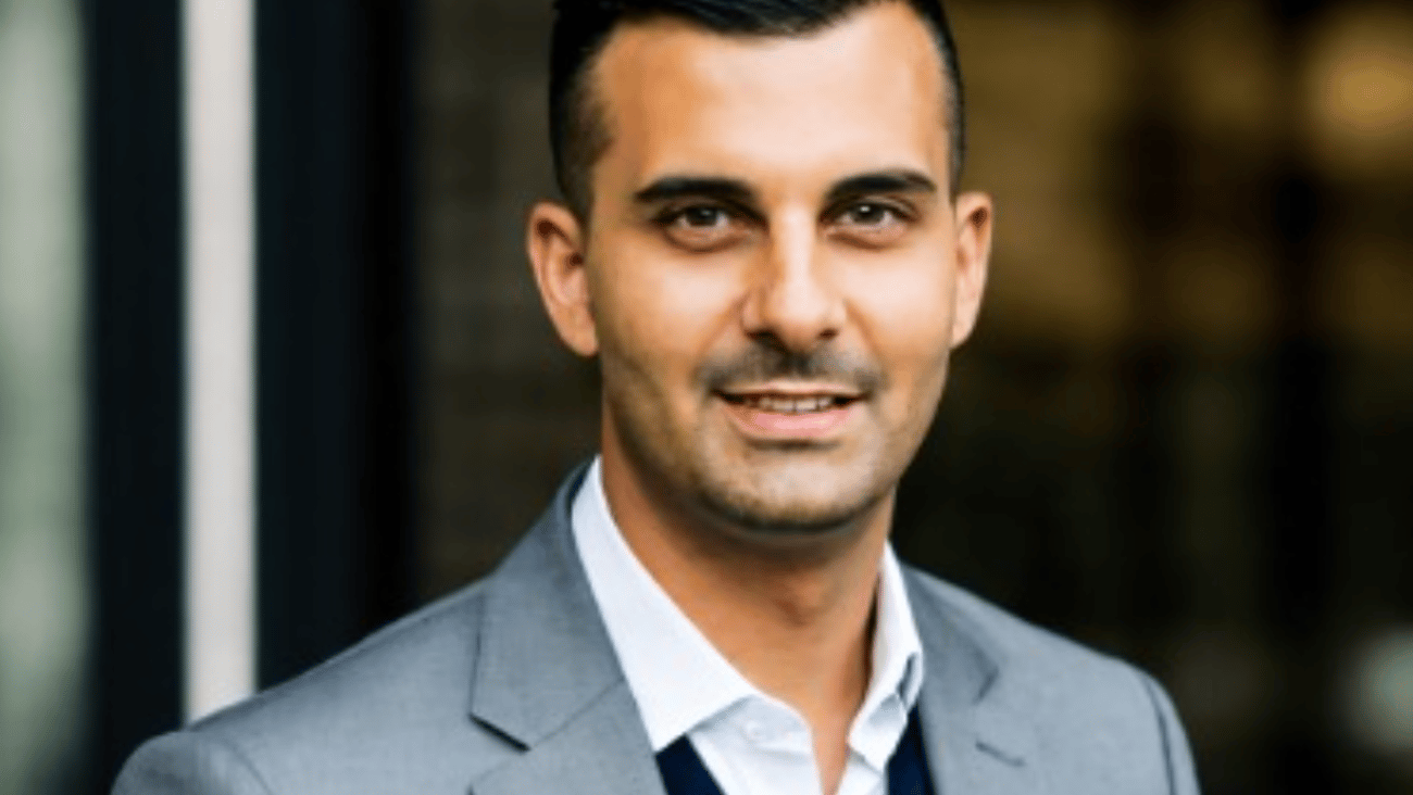 Dr. Eugene Maida in a grey suit posing for a picture