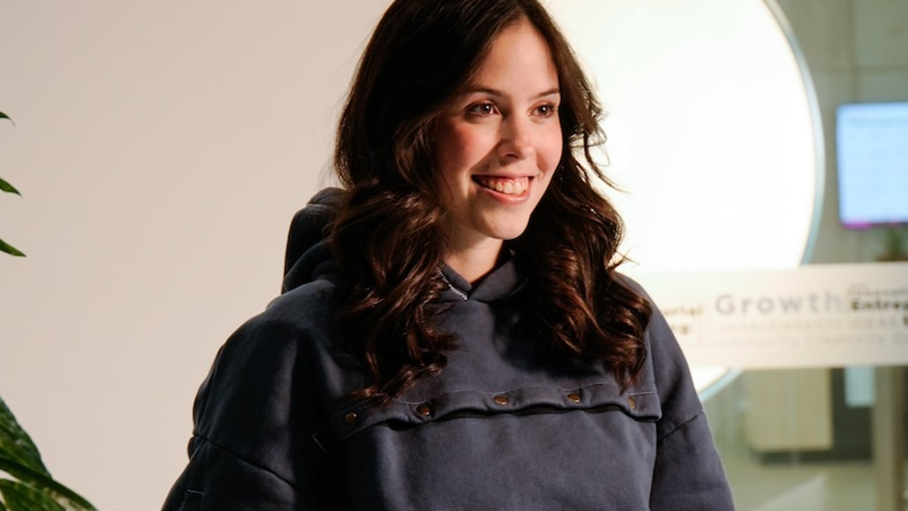Maddison Tory wears a dark grey hoodie with snaps to allow for IV access. 