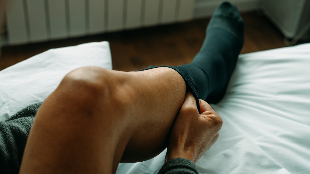 Young person pulling on a compression sock