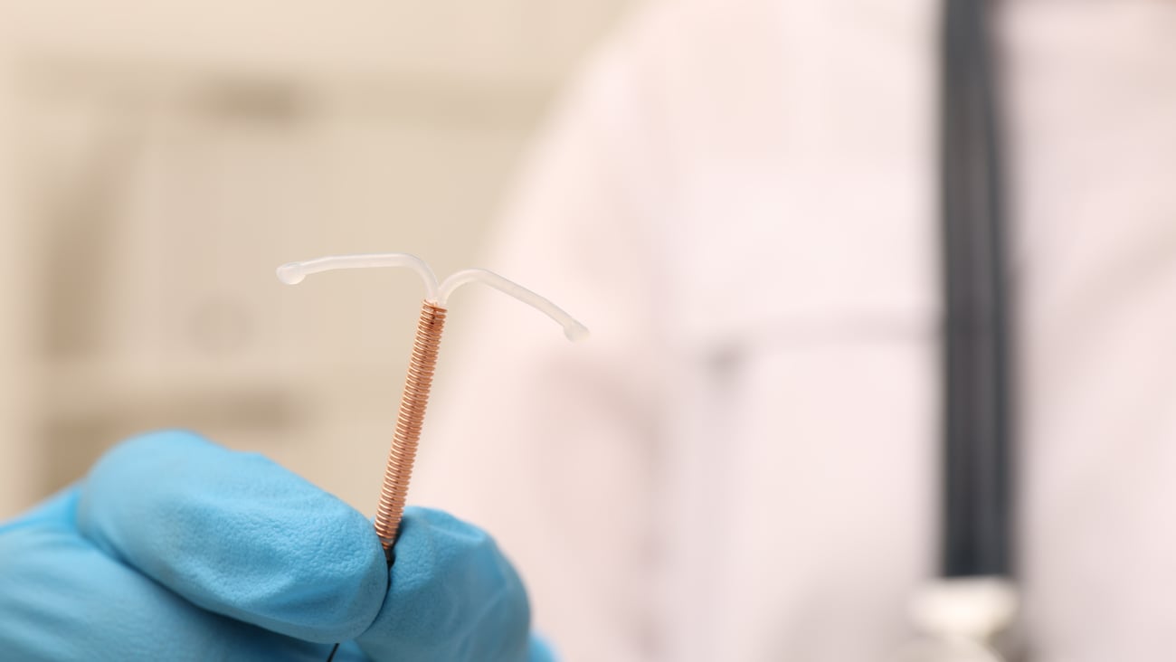 A doctor holding an IUD.