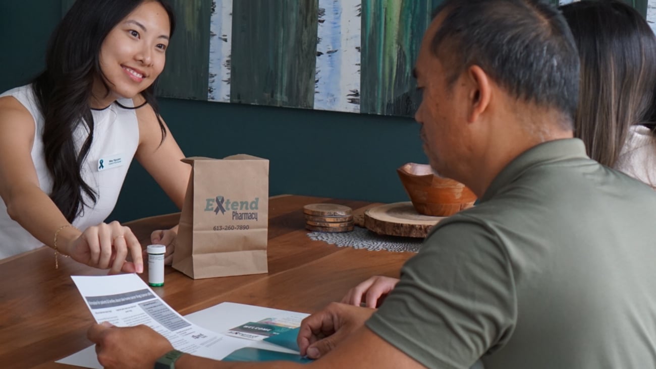An Extend pharmacist is seen with a patient at a table. (Extend Pharmacy)